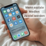Eine Frau hält kraftlos ein Smartphone in der rechten Hand, auf dessen Bildschirm Nachrichteneingänge von Facebook, Instagram, Pinterest und WhatsApp angezeigt werden. Die Hand liegt müde auf einer weichen Decke, was ein Symbol für Überforderung durch soziale Medien bei Long Covid und ME/CFS darstellt.