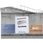 Es sind Plakate in unterschiedlicher Größe und Farbe an einer grauen rissigen Betonwand zu sehen, die auf Liegenddemo bei ME/CFS aufmerksam machen: „Anerkennung, Versorgung, Forschung", „#LiegendDemo" und „#ME/CFS #LongCovid" zum ME/CFS Awarenessday